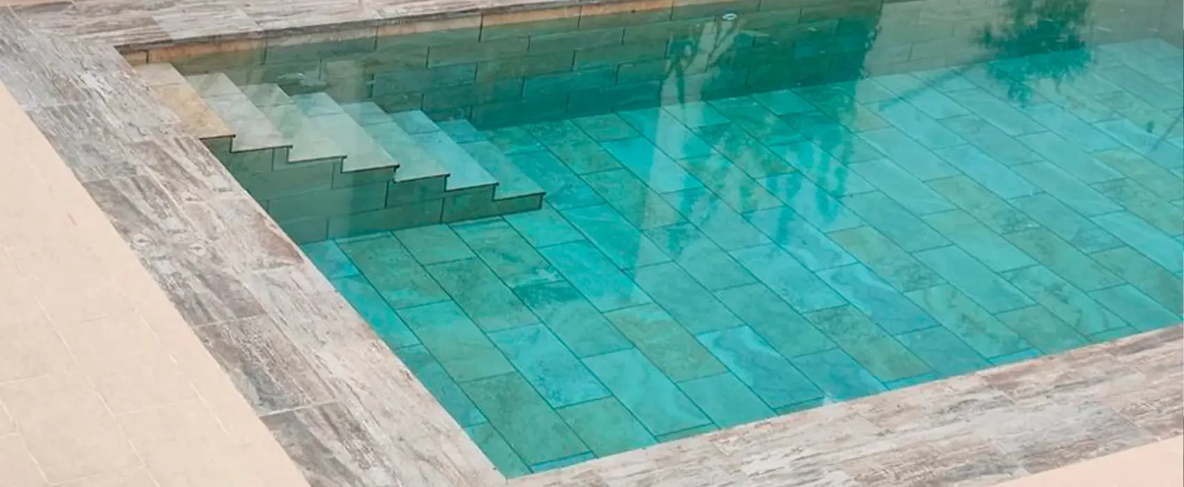 Escalera interior y agua turquesa en una piscina con porcelanico revestimiento piscinas Escalera interior y agua turquesa en una piscina con porcelanico revestimiento piscinas