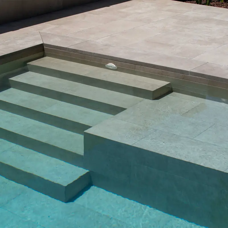 Piscina porcel&aacute;nica con acabado Litos Sabana en tonos tierra, ejemplo de piscinas porcel&aacute;nicas de dise&ntilde;o natural