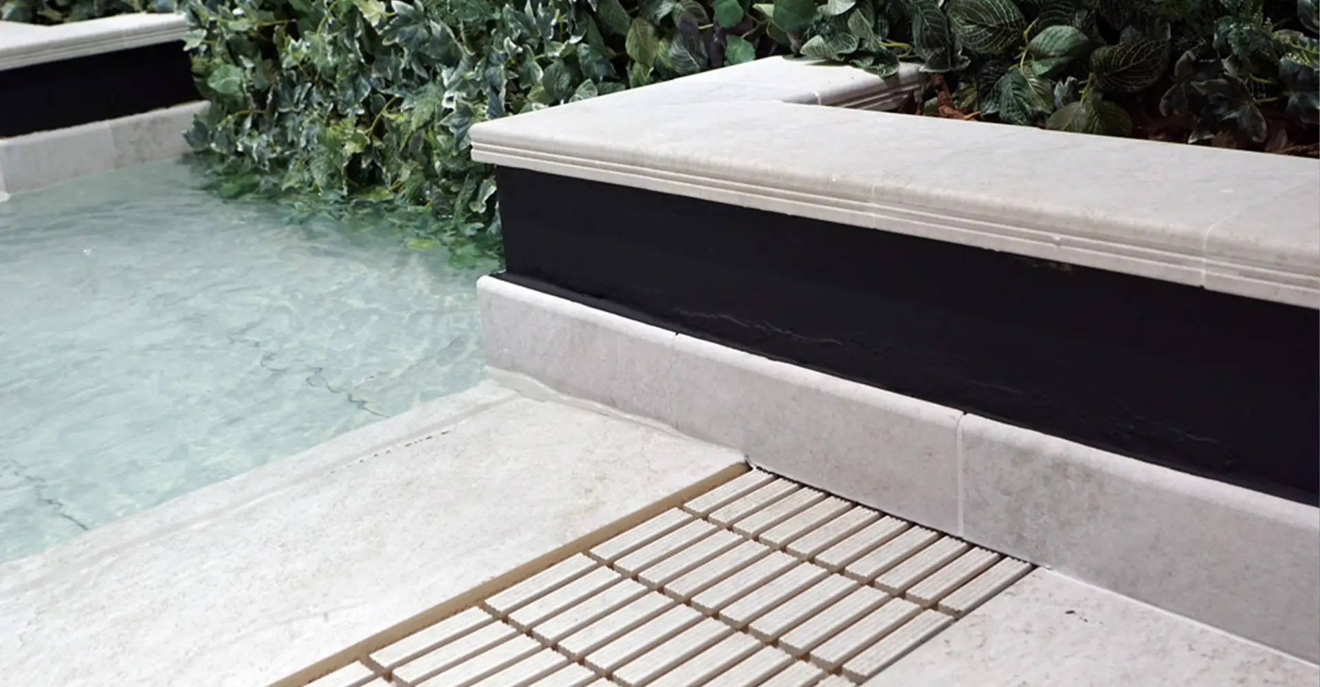 Detalle de desagüe junto al agua con piscina suelo porcelanico y vegetación cercana Detalle de desagüe junto al agua con piscina suelo porcelanico y vegetación cercana