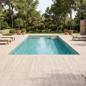 Piscina rectangular rodeada de árboles con suelo porcelanico piscina en tonos claros Piscina rectangular rodeada de árboles con suelo porcelanico piscina en tonos claros
